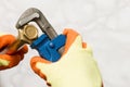 Hands in Gloves Turning a Nut with a Pipe Wrench Royalty Free Stock Photo
