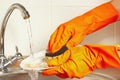 Hands in gloves wash the dishes under running water in kitchen Royalty Free Stock Photo