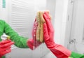 Hands in gloves wash the mirror. Royalty Free Stock Photo