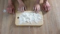 Hands of grandmother and granddaughter pouring flour on plank, cooking time