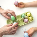 Hands of grandson and grandmother make crafts from Easter eggs. Easter concept and family traditions and pastime