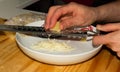 Hands grating cheese on a plate