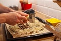 Hands grating cheese on top of pizza or flammekueche