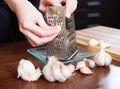 Hands grating garlic with grater