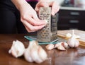 Hands grating garlic with grater