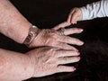 Hands of great grandma and her great baby grandson