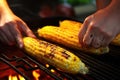 hands grilled corn from the cob
