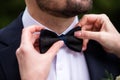 the hands of the groom bow tie. stylish groomsmen helping happy groom getting ready in the morning for wedding ceremony. luxury