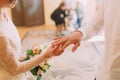 Hands of the groom and bride wearing ring on finger, wedding ceremony in registry office, close-up Royalty Free Stock Photo