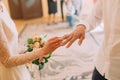 Hands of the groom and bride wearing ring on finger, wedding ceremony in registry office, close-up Royalty Free Stock Photo