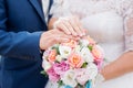 Hands of groom and bride with wedding rings and flowers bouquet. concept of love and marriage Royalty Free Stock Photo