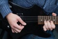 Hands of guitarist with an electric guitar pick. Abstract music background