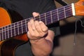 The hands of the guitarist make the strings of the instrument vibrate
