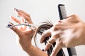 Hands of a hair stylist trimming hair with a comb and scissors Royalty Free Stock Photo