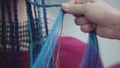 The hands of the hairdresser quickly braided African braids