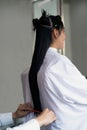 Hands of hairstylist cut hair of beauty woman with long hair using scissors. Hair care in professional beauty salon.