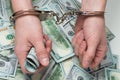 Hands in handcuffs hold money