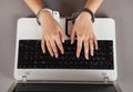 Hands and handcuffs on laptop keyboard. Cyber Crime Royalty Free Stock Photo