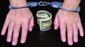 Hands in handcuffs. A wad of dollars tied with a rubber band Royalty Free Stock Photo