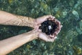 Hands with handful of sea stones under water Royalty Free Stock Photo