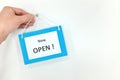 Hands hanging now open sign on door front. Back to business concept. Royalty Free Stock Photo