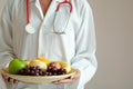 The hands of a healthy nutritionists, she holds a bowl with fruits, apples, grapes and avocados