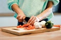 Hands of healthy young woman cutting fresh vegetables in the kitchen at home Royalty Free Stock Photo