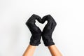 Hands heart made of black medical gloves isolated on white background