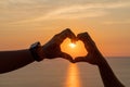 Hands heart sea sanset. Hands forming a heart shape made against the sun sky of a sunrise or sunset on a beach Royalty Free Stock Photo