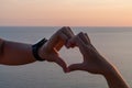 Hands heart sea sanset. Hands forming a heart shape made against the sun sky of a sunrise or sunset on a beach Royalty Free Stock Photo