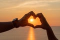 Hands heart sea sanset. Hands forming a heart shape made against the sun sky of a sunrise or sunset on a beach Royalty Free Stock Photo