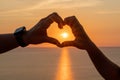 Hands heart sea sanset. Hands forming a heart shape made against the sun sky of a sunrise or sunset on a beach Royalty Free Stock Photo