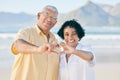 Hands, heart and a senior couple on the beach together during summer for love, romance or weekend getaway. Portrait Royalty Free Stock Photo