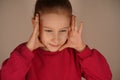 With hands by her temples, the girl blocks her peripheral view, creating an impression of deep focus. Her posture Royalty Free Stock Photo