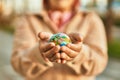 Hands of hispanic woman holding small world ball standing at the city Royalty Free Stock Photo