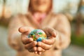 Hands of hispanic woman holding small world ball standing at the city Royalty Free Stock Photo