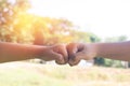 Hands hit and bumping together with sun light on grass background Royalty Free Stock Photo