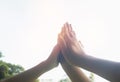 Hands hit and bumping together with sun light on sky background. Royalty Free Stock Photo