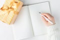 Hands hold an blank notebook among gift box. Flat lay. Royalty Free Stock Photo