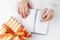 Hands hold an blank notebook among gift box. Flat lay. Royalty Free Stock Photo