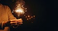Hands hold burning sparkler, sparkler sparks fly, sparkler lights night Royalty Free Stock Photo