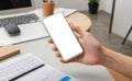 hands hold cell phone with blank white screen, for displaying app interface or website design. Person in office environment hold Royalty Free Stock Photo