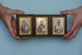 Hands hold the Christian icon of Christ, the mother of God and St. Nicholas the wonderworker, the patron saint of sailors and Royalty Free Stock Photo