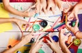 Hands hold colorful markers, pencils and paints. Art and craft concept. Artists hands with stationery and paper Royalty Free Stock Photo