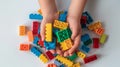 The Hands of the kids hold colorful toys bricks and blocks for building toys on a white background. Generative AI Royalty Free Stock Photo