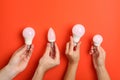 Hands hold energy saving bulbs on red background Royalty Free Stock Photo