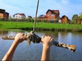 Hands hold rope swing before jump into the water on the lake and mansion hous background Royalty Free Stock Photo