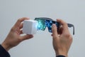 Hands hold futuristic augmented reality glasses and a white device Royalty Free Stock Photo