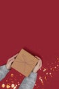 Hands hold gift box tied with rope on a red background Royalty Free Stock Photo