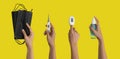 Hands hold masks, thermometer, pulse oximeter, medical and healthcare equipments isolated on yellow background. Medical and